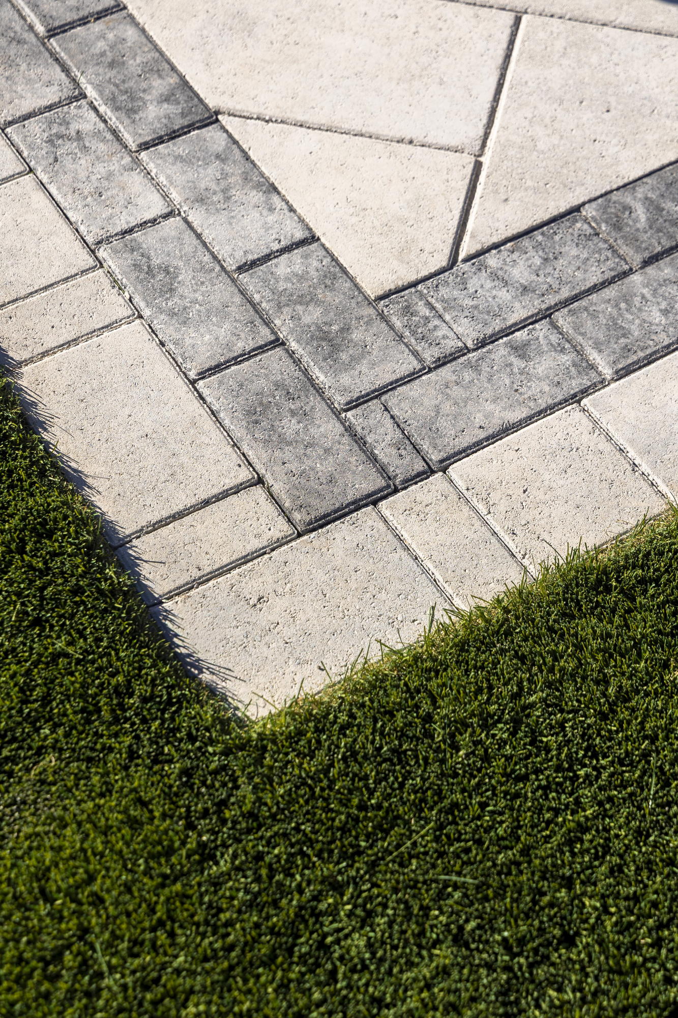 Paver-to-turf edge detail with a herringbone paver field