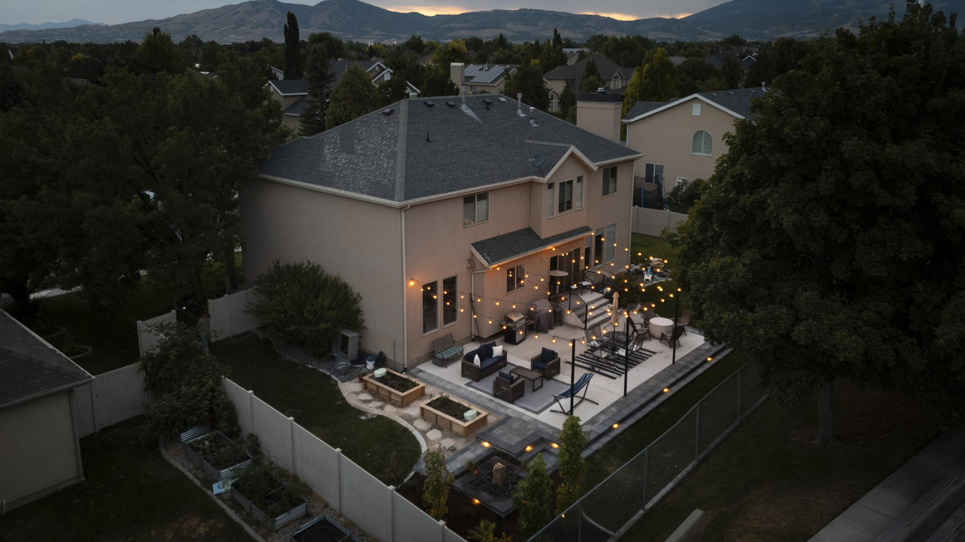 Twilight aerial of a lit patio with the valley behind